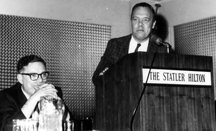 Hal Clement (Isaac Asimov seated) speaks at one of the early editions of Boksone - a Science Fiction convention held in the Boston area to this day (photo uncredited, from 1966)
